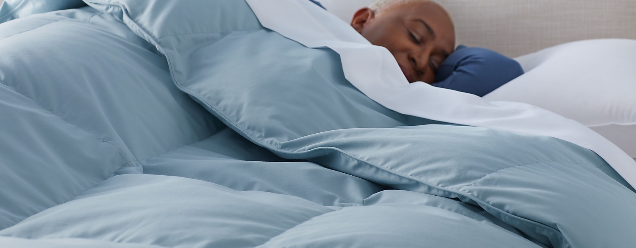 women alseep under blue down alternative comforter