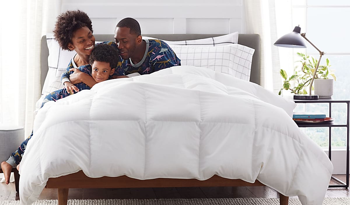 family laying on white comforter