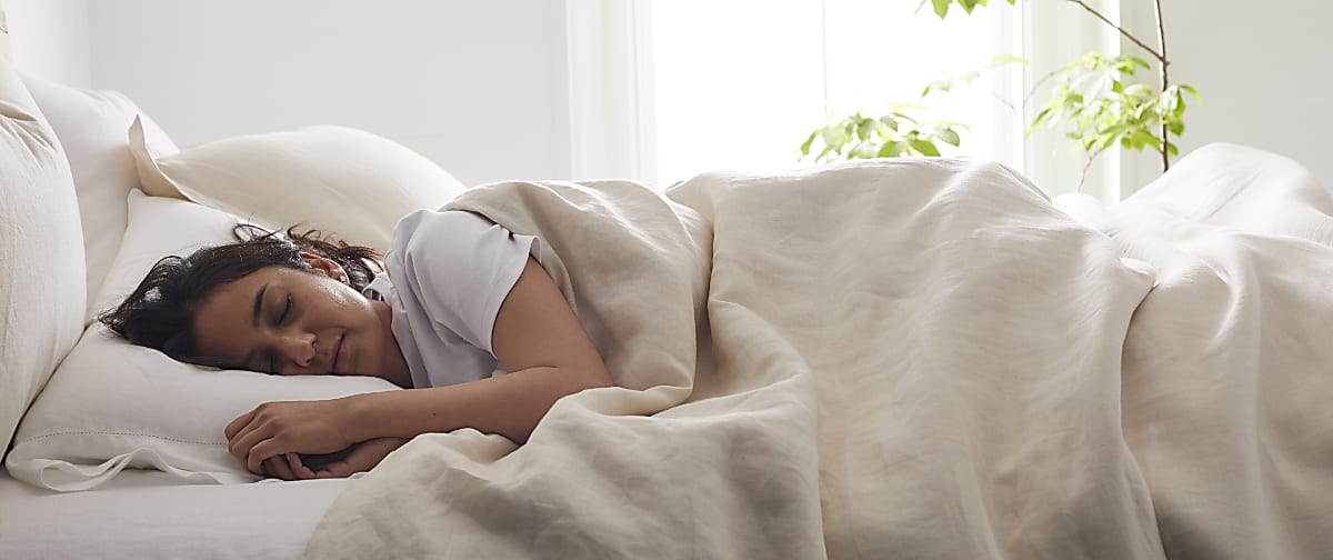 woman sleeping under duvet