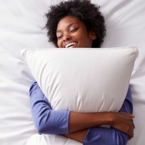 woman hugging down pillow