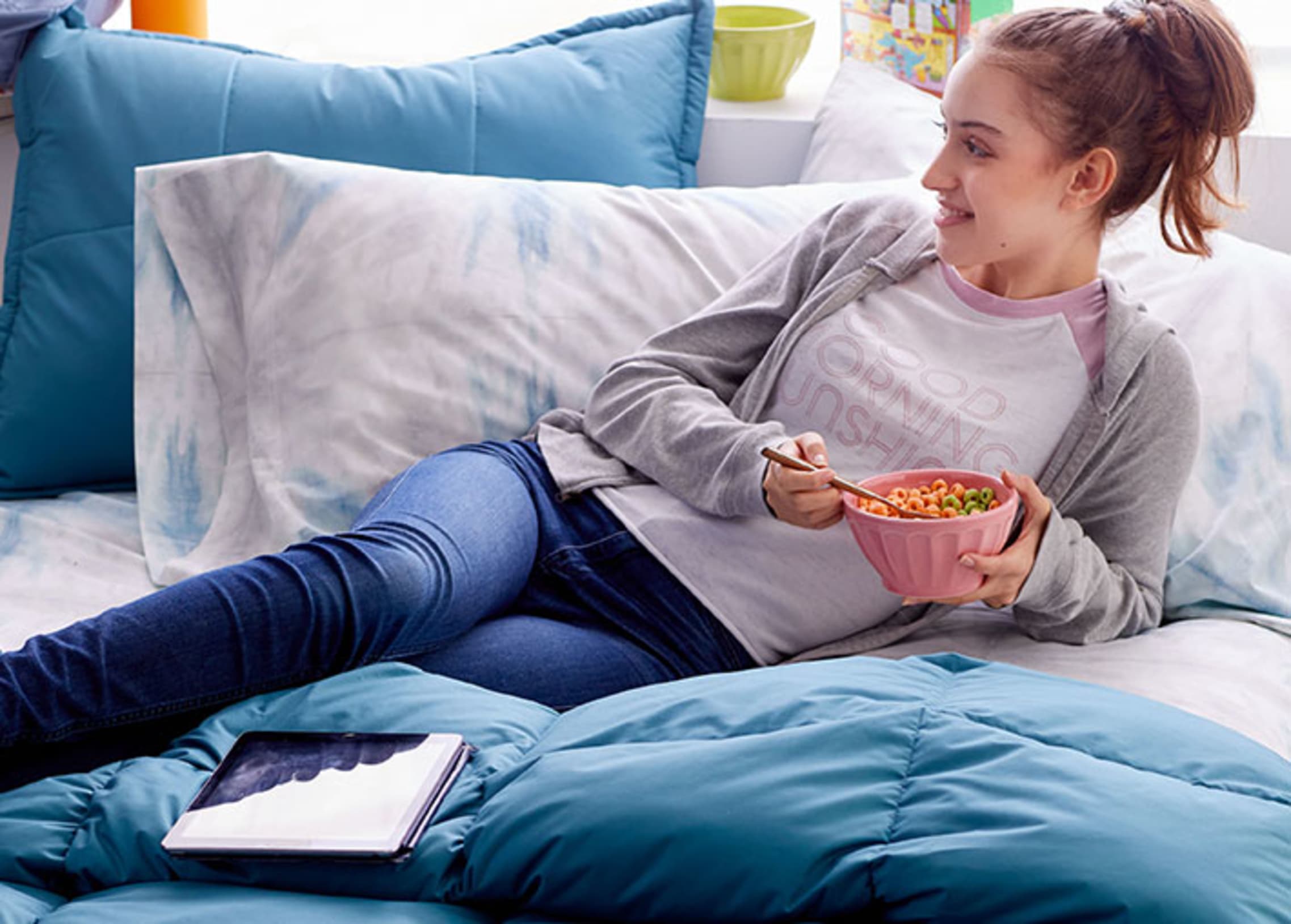 girl eating breakfast on comforter