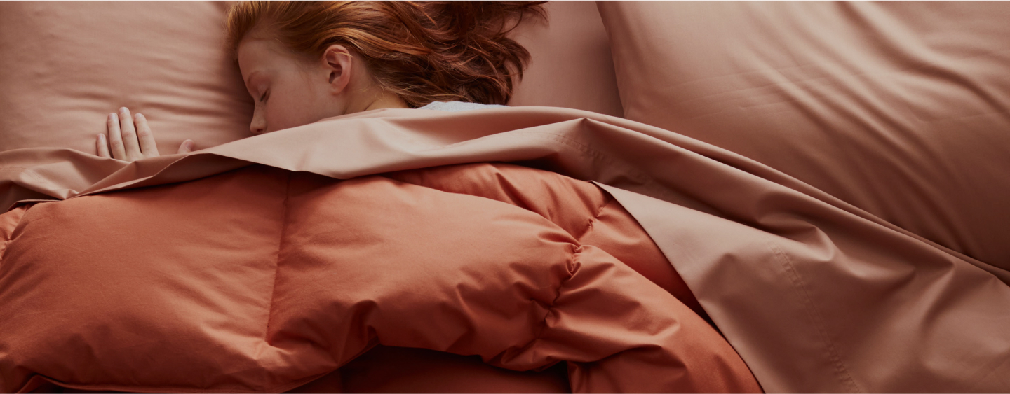 woman sleeping under comforter